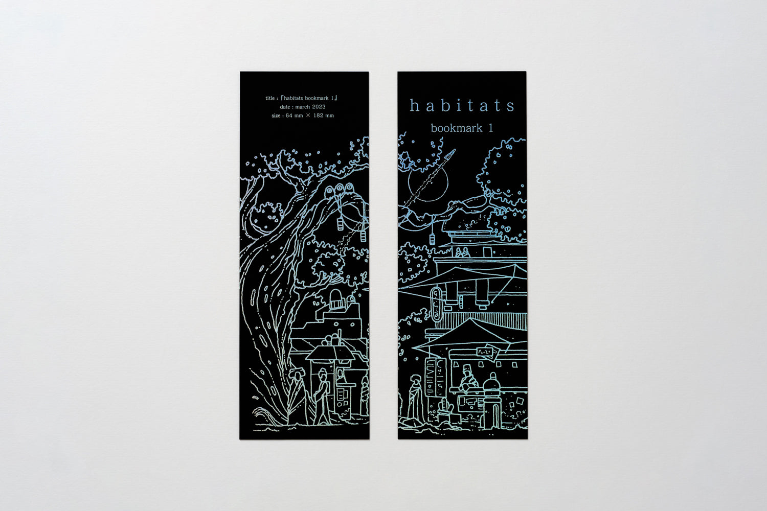 A photo of Habitats Bookmark 1, showing both faces of the bookmark side by side. Small figures stand in front of science-fiction market canopies, with giant trees behind. The illustration, Habitats logo and details text are all printed in holographic foil, on a heavy black paper.